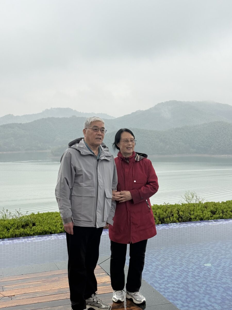 爸爸妈妈在无边泳池边合影，天目湖在身后 / Parents at the infinity pool with Tianmu Lake behind them