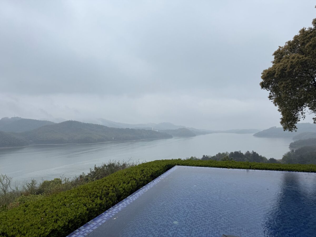 天目湖更开阔的全景，远山、绿植和湖面 / A wider sweep of Tianmu Lake — mountains, green hills, and still water