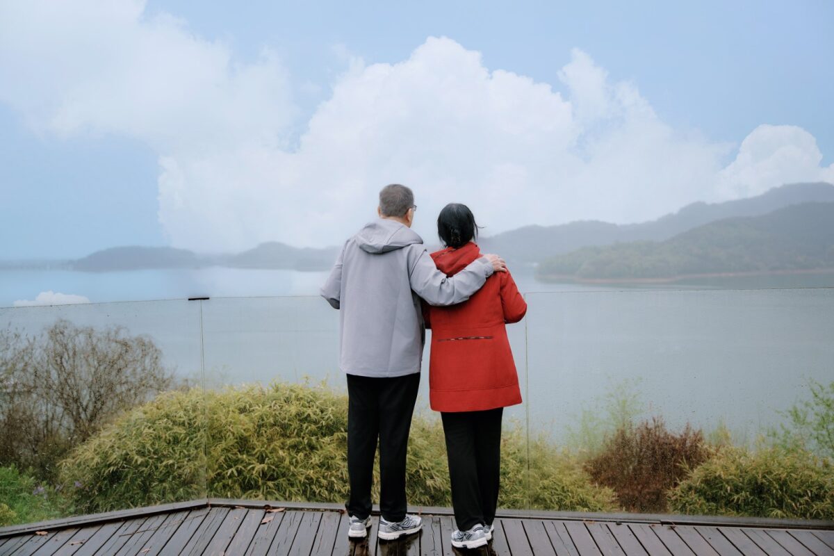 爸爸妈妈在天目湖御水温泉的无边泳池边，望向远山 / Parents at the Tianmu Lake infinity pool, looking out at the distant mountains