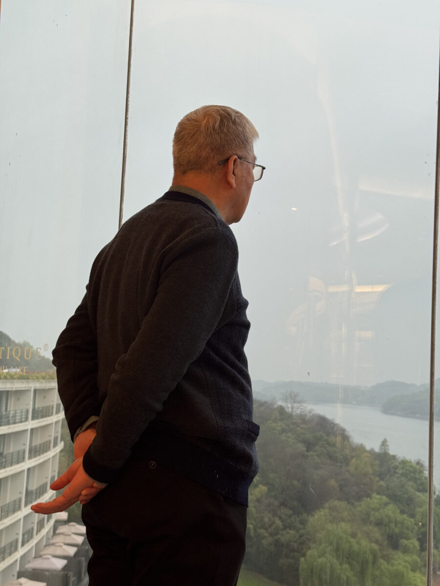 爸爸靠在走廊窗前看天目湖 / Dad at the window, looking out at Tianmu Lake